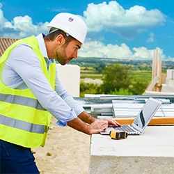 handsome young man foreman architect supervising a new house construction site